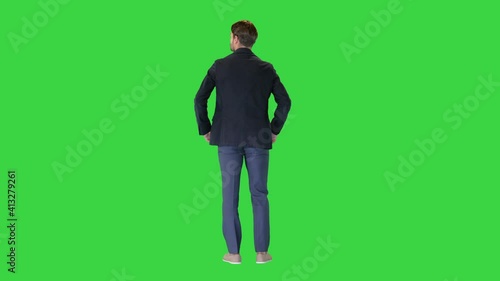 Confident businessman standing with hands on hips looking around on a Green Screen, Chroma Key. photo