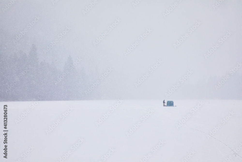 Original winter photograph a an ice fisherman and his tent far in the distance on a frozen lake Original winter photograph a an ice fisherman and his tent far in the distance on a frozen lake