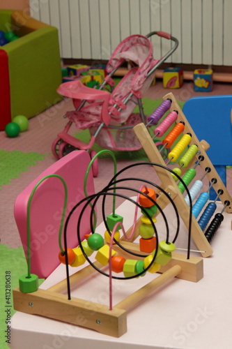 Children's colorful wooden 3D toy labyrinth on table in kids play room in kindergarten, early development of kids creativity