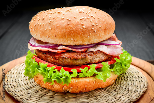 Bacon burger with beef cutlet on wooden background