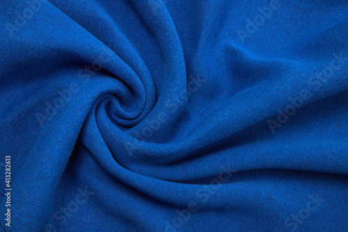 Pleats on fabric, knitted material of bright blue color, folds