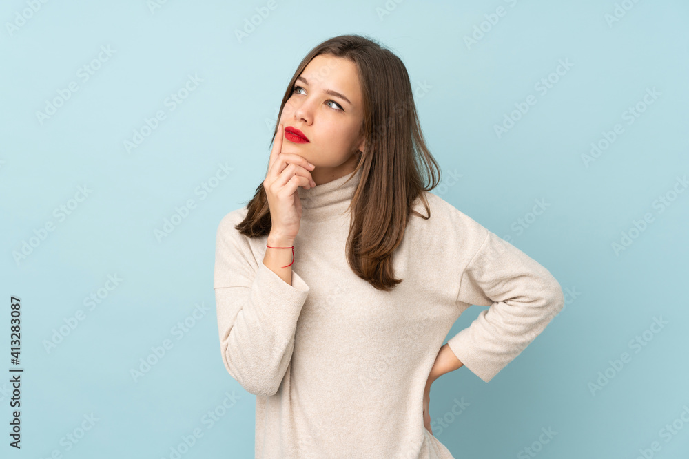 Teenager girl isolated on blue background thinking an idea Teenager girl isolated on blue background thinking an idea