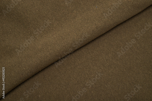 Pleats on fabric, knitted material of khaki color, folds