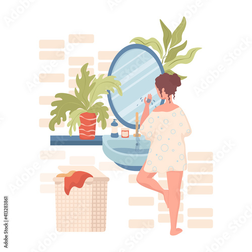 Girl cleansing or moisturizing face in bathroom vector flat illustration. Woman using spa creams for face and body skincare. Everyday hygienic routine. Bathroom interior design with laundry basket.