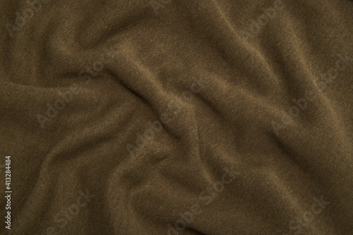 Pleats on fabric, knitted material of khaki color, folds