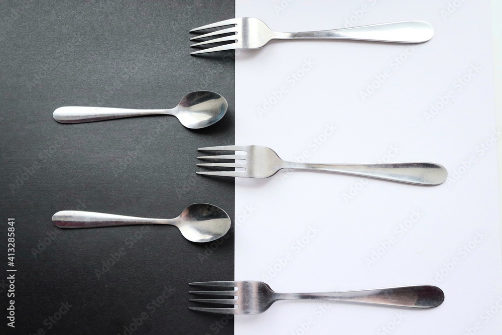 Forks and spoons on black and white background

