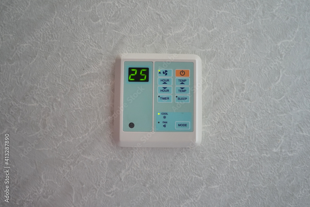 The air conditioner control panel is installed on the wall and the temperature is set at 25 degrees Celsius. The air conditioner control panel is installed on the wall and the temperature is set at 25 degrees Celsius.
