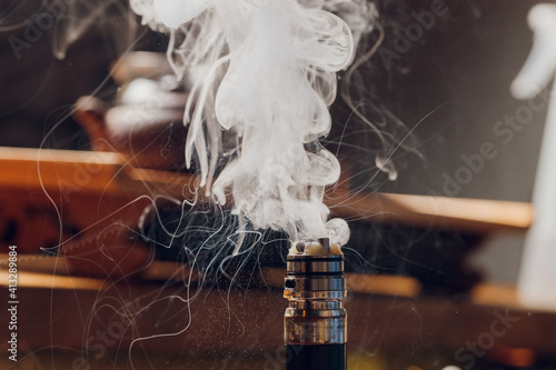 Splash glicerine on vape spiral. Big clouds of fog with visible tracers. Vape culture and no smoking. photo