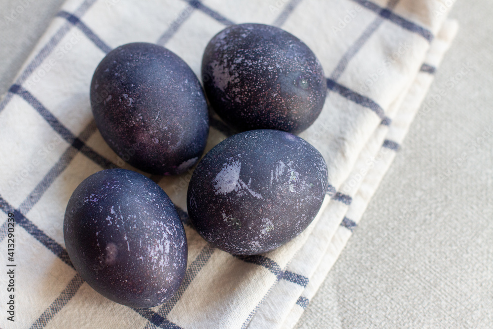 Blue easter eggs on a white checked towel. Painted eggs in hibiscus. Blue easter eggs on a white checked towel. Painted eggs in hibiscus.