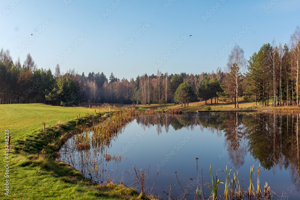 Obraz premium Autumn forest lake near golf field in Belarus