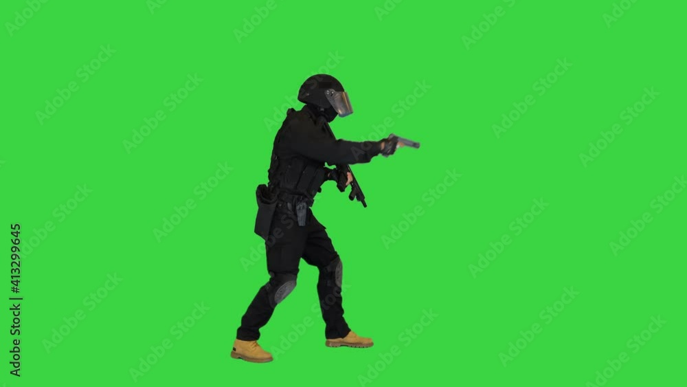 Armed man in protective cask aiming with a pistol on a Green Screen, Chroma Key. Armed man in protective cask aiming with a pistol on a Green Screen, Chroma Key.