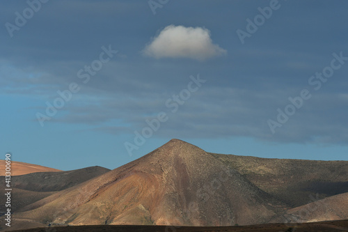 A volcanic mountain with a single cloud on top. Lanzarote, Spain.