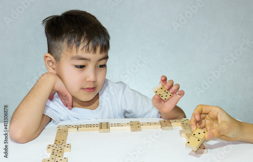 two children playing dominoes sitting in the living room childhood concept