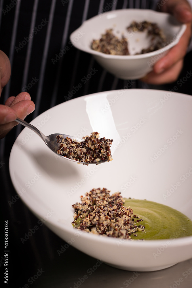 Chef cook preparing salad with salmon and avocado in his kitchen. Freezer food prepare in process vegetarian salad by chef hand in home kitchen. Dark black background with Text area for design menu Chef cook preparing salad with salmon and avocado in his kitchen. Freezer food prepare in process vegetarian salad by chef hand in home kitchen. Dark black background with Text area for design menu