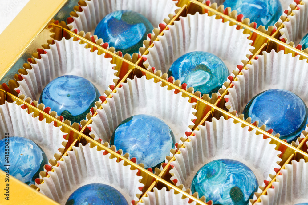 Obraz premium Handmade blue candies in a gold box