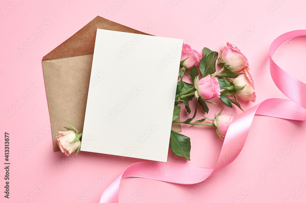 Greeting card mockup with copy space, pink ribbon and roses flowers on paper background Greeting card mockup with copy space, pink ribbon and roses flowers on paper background