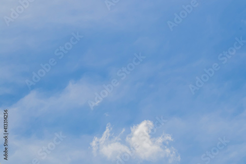 Blue sky with light cloud cover and whispy cloud near bottom