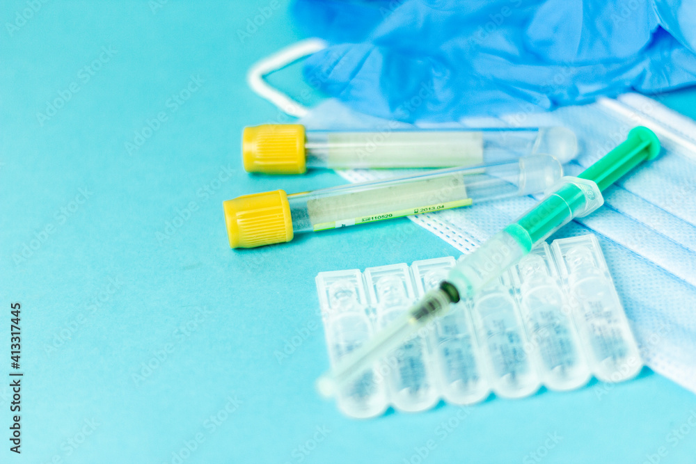 Medical vials for injection, syringe for injection, mask gloves on a blue background. Admission vaccination, flu shot. Medical vials for injection, syringe for injection, mask gloves on a blue background. Admission vaccination, flu shot.