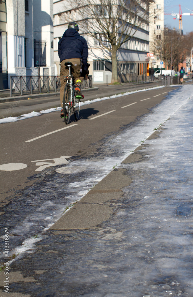 back-sided anonymous man riding bicycle on winter bicycle lanes