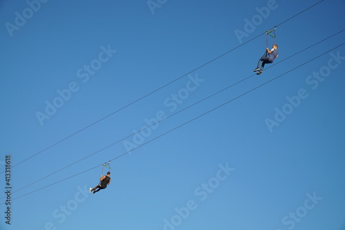 People ride bungee on zip lines