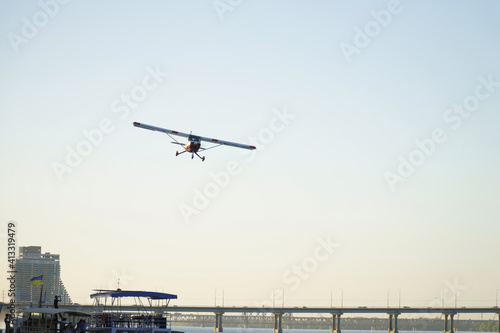 The plane is flying over the bridge. Air show in honor of the day of the city of Dnipro.