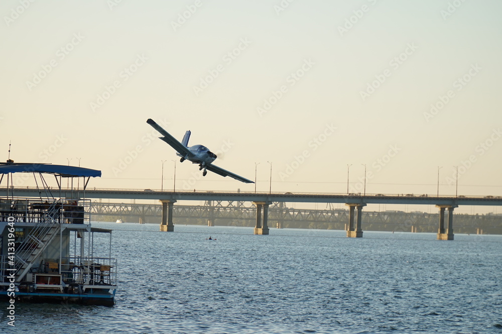 The plane is flying over the bridge. Air show in honor of the day of the city of Dnipro.