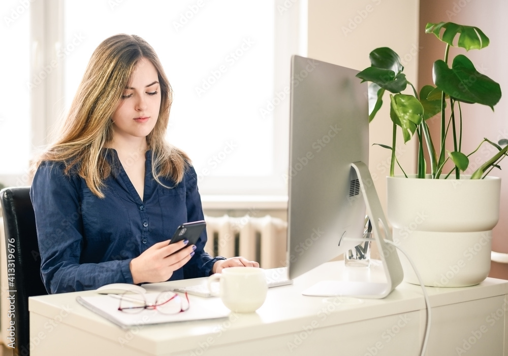 cropped shot of a young woman working from home using smart phone and computer, woman's hands using smart phone in interior, woman at home workplace using technology, cropped shot of a young woman working from home using smart phone and computer, woman's hands using smart phone in interior, woman at home workplace using technology,