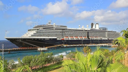 Coastline of Caribbean island with cruise ship in port on sunny day