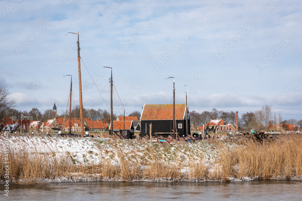Picturesque Dutch landscape with historic houses and masts of sailing ships