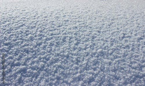 Natural winter background. Crystallized snow. Particular light.