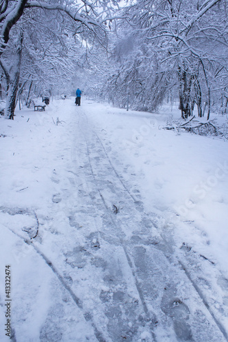city park road covered with people and snow after snow storm wntery cold day outdoor  © АliVa