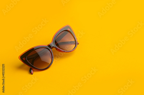 Red feminine women's sunglasses with delicate lines on a yellow background.