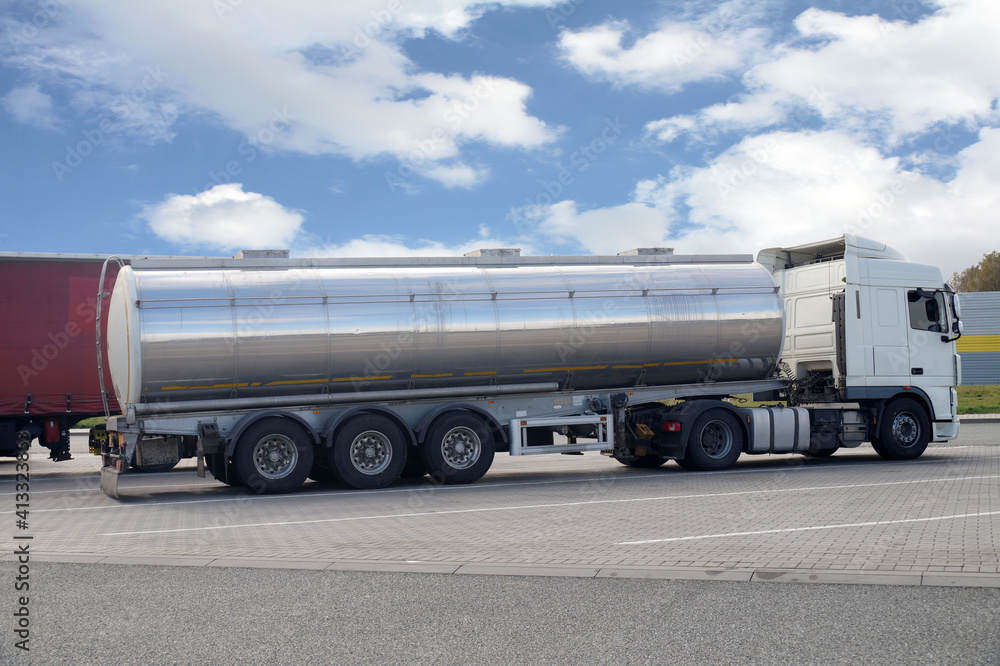 Truck stop next to the highway. A truck during a break, a tanker in the foreground. Truck stop next to the highway. A truck during a break, a tanker in the foreground.