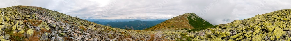 Panorama of mountain peaks. Panorama of rocky placers and storm clouds