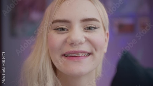 Happy cheerful young woman teenager with teeth brace portrait, looking at camera with cute smile. Student relaxing indoors after college or university, generation z millennial.