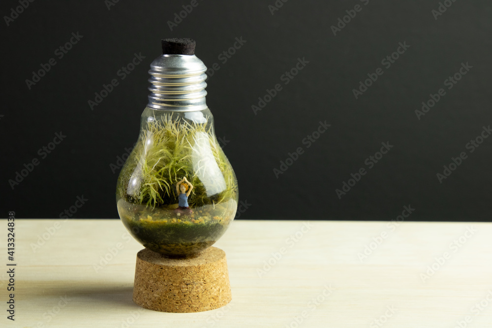 Lamp terrarium with a women practicing Yoga with a black and wooden background Lamp terrarium with a women practicing Yoga with a black and wooden background