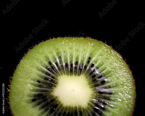 slice of kiwi on black background