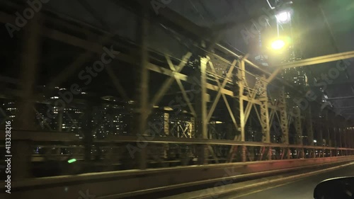 crossing the Brooklyn Bridge - driving across with Freedom Tower Manhattan skyline view at night New York City NYC