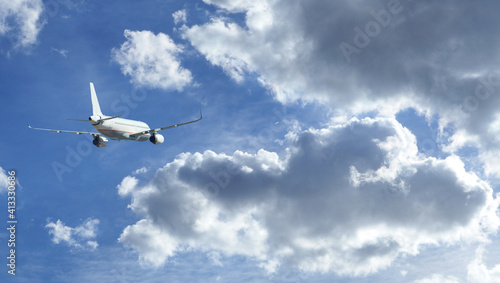 Zoom photo of passenger airplane taking off in deep blue cloudy sky
