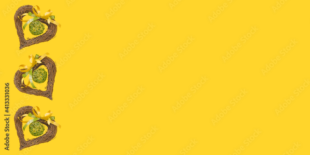 Easter background with straw hearts on yellow background 