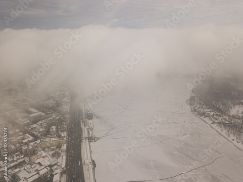 Fog over a frozen river in Kiev. Aerial drone view. Foggy winter morning.
