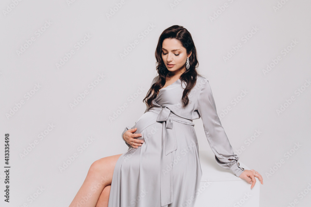 Pregnancy photoshoot of a beautiful couple, future parents in a gray dress and suit Pregnancy photoshoot of a beautiful couple, future parents in a gray dress and suit