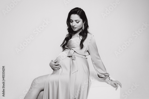 Pregnancy photoshoot of a beautiful couple, future parents in a gray dress and suit