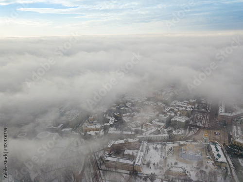 Fog over the snowy Kiev city. Aerial drone view. Foggy winter day.