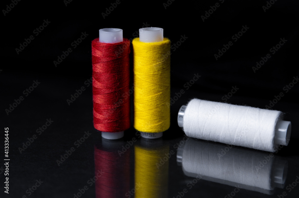 colored skeins of thread on a dark background and a mirror surface colored skeins of thread on a dark background and a mirror surface