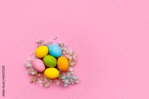 Easter bunny. Happy Easter holiday background concept.Flat lay colorful bunny egg with accessory to celebration on modern rustic pink pastel paper at home office desk.
