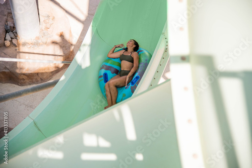 Cute teenage plus size girl in water Park. Fun on the water. Teen girl and boy having fun in the water slider . Happy children's vacation outdoor.
