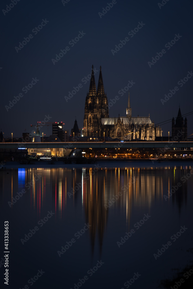 Cologne Cathedral by night, iluminated, reflection in the Rhine river