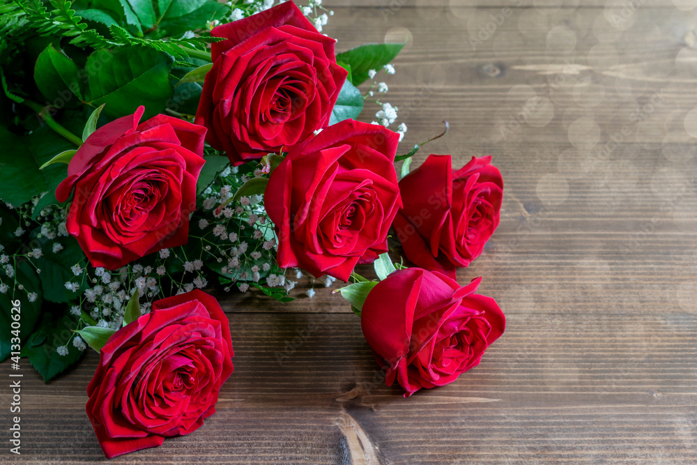 Red roses bouquet on the wooden table in sunlights. Nice gift for Valentine's day or Mother's day. Red roses bouquet on the wooden table in sunlights. Nice gift for Valentine's day or Mother's day.