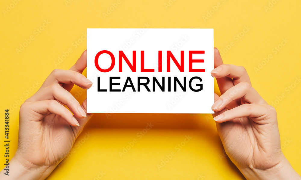 Female hands hold card paper with text online learning on a yellow background. Education and study concept Female hands hold card paper with text online learning on a yellow background. Education and study concept